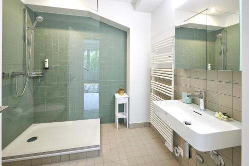 a bathroom with a shower and a sink and a tub at Neustadt Apartments managed by Hotel Central Luzern in Lucerne