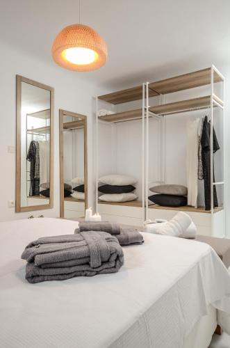 a bedroom with a large white bed with mirrors at Villa Tranquillity in Kastraki Naxou