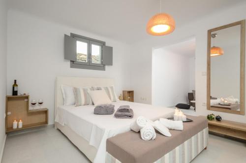 a bedroom with a large white bed with towels on it at Villa Tranquillity in Kastraki Naxou