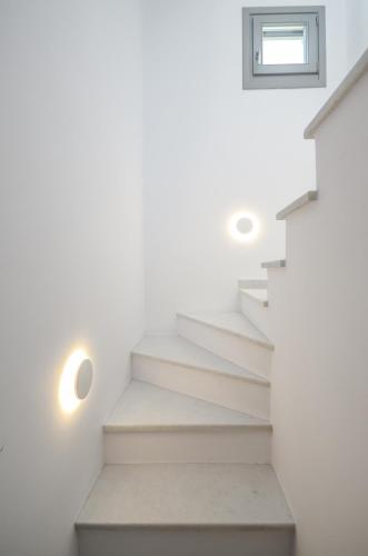 a staircase in a house with white walls and a window at Villa Tranquillity in Kastraki Naxou