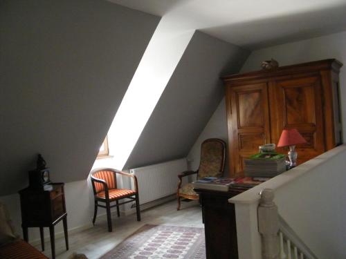 a room with a staircase with chairs and a desk at Chez Yolande in Nothalten