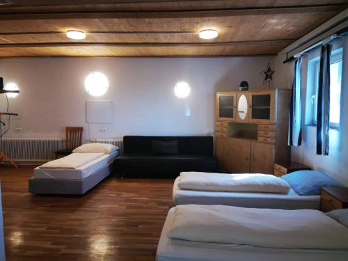 a living room with three beds and a couch at Geinberg Suites & Via Nova Lodges in Polling im Innkreis