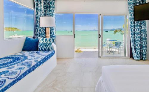 a bedroom with a bed and a view of the ocean at So KohKoon Beach Resort in Bangrak Beach