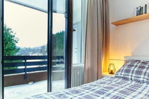 a bedroom with a bed and a large window at Gemütlich - Mountainbike - Pool & Sauna - Netflix in Winterberg