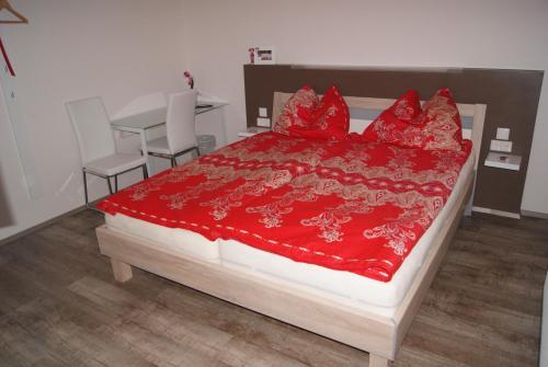 a bedroom with a bed with a red comforter at Privatzimmer Mitterbacher in Fohnsdorf