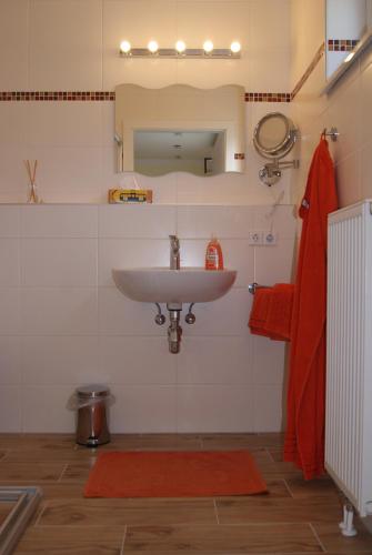 baño con lavabo y alfombra roja en Privatzimmer Mitterbacher, en Fohnsdorf