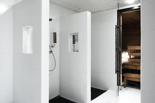 a bathroom with a shower with white tiles at Hotel Verso in Jyväskylä