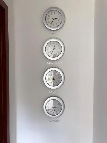 three clocks on a wall with different time zones at Agnieszkas Pension in Havelberg