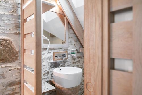 baño con lavabo blanco en una habitación en La Vinotière Chambres Appartements Spa, en Le Conquet