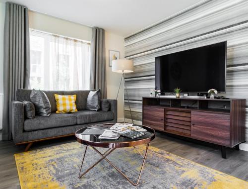 a living room with a couch and a flat screen tv at Fortified Luxury Apartment in Chatham