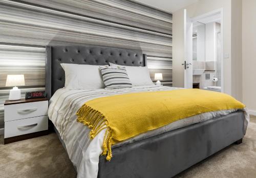 a bedroom with a large bed with a yellow blanket at Fortified Luxury Apartment in Chatham