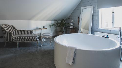 una vasca da bagno bianca in un bagno con due sedie di V Hotel Helsingborg; BW Premier Collection a Helsingborg