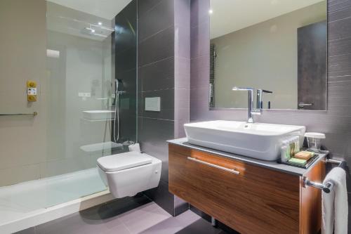 a bathroom with a sink and a toilet and a shower at Hotel Cismigiu in Bucharest