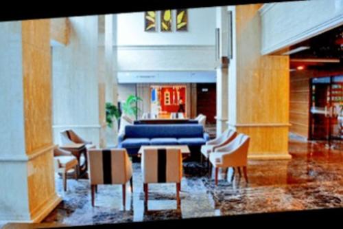 a living room with chairs and a blue couch at Capitol Park Residence salemba-cozy room in Jakarta