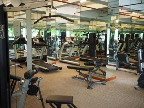 Capitol Park Residence salemba-cozy room في جاكرتا: صالة ألعاب رياضية مع مجموعة من معدات التمرين فيها
