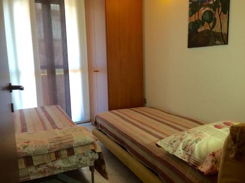 two beds in a room with a window at Appartamento Rosa in Padova