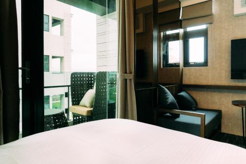 a room with a bed and chairs and a window at Tsang Kuo Resort in Wujie