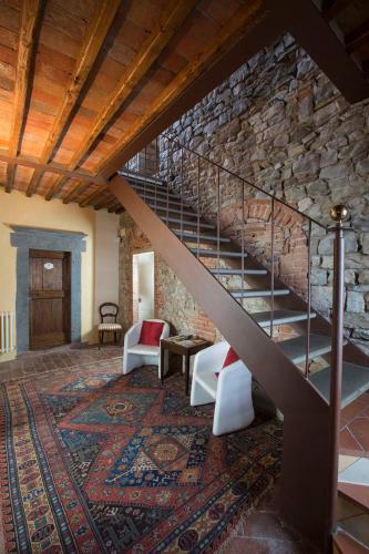 a staircase in a room with a stone wall at Rocca Di Castagnoli in Gaiole in Chianti