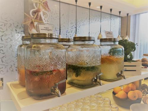 a shelf with four glass jars filled with liquid at Hotel Liberty Beach - Parking & Beach in Riccione