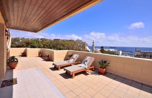 a patio with two lounge chairs and a view of the ocean at CENTER Penthouse - MEDIEVAL Town 10'- BEACH 2' in Rhodes Town