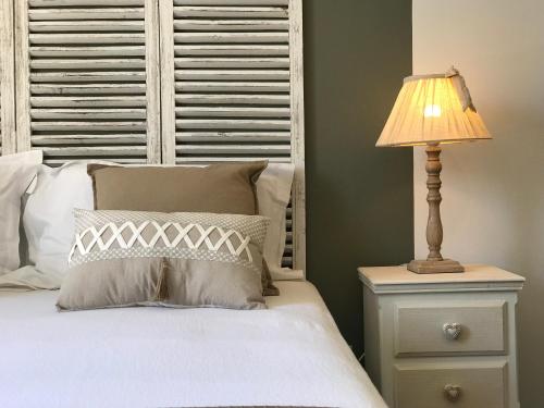 a bedroom with a bed with a lamp on a night stand at Ô 36 Rempart Sud B&B in Aigues-Mortes