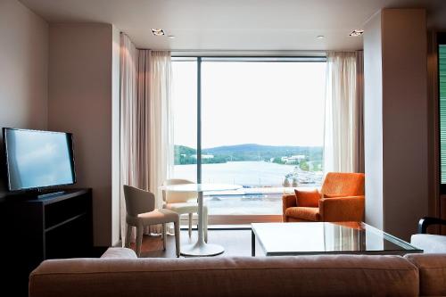 a living room with a couch and a large window at Solo Sokos Hotel Paviljonki in Jyväskylä
