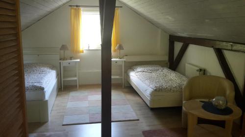 Habitación con 2 camas, mesa y ventana en Kapitänsvilla en Ulsnis