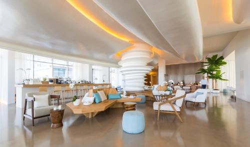 Habitación grande con vestíbulo con sillas y mesas. en Nikki Beach Resort & Spa Dubai, en Dubái