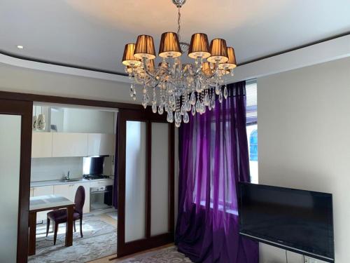 a dining room with a chandelier and a kitchen at PREMIUM apartments in the center of Baku in Baku