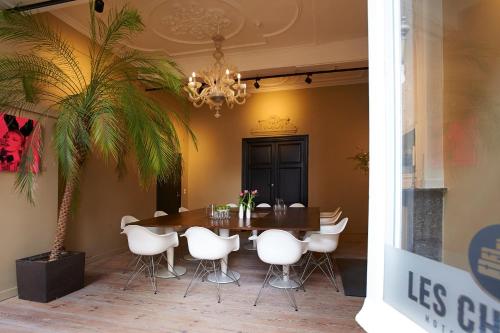 a dining room with a table and white chairs at Hotel Les Charmes in Maastricht