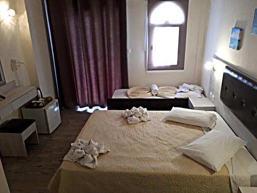 a hotel room with two beds and a window at Summer Beach Hotel in Polykhrono