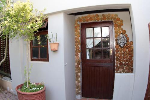 a house with a wooden door and a window at The Buddha Garden in Cape Town