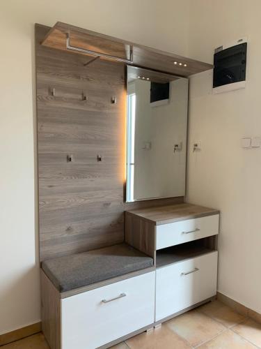 einen Schrank mit weißen Schränken und einem Spiegel in der Unterkunft Apartmán Monny in Frymburk