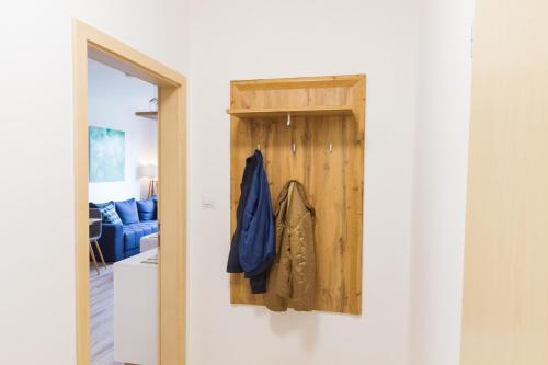 a hallway with a wooden door and a blue couch at Spacy Modern Apartment near Hockey Stadium in Bratislava