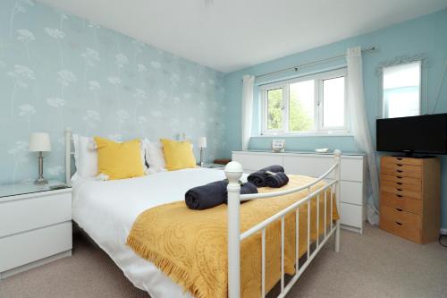 sypialnia z łóżkiem z żółtymi i niebieskimi ścianami w obiekcie Home from Home by StayStaycations w mieście Quedgeley