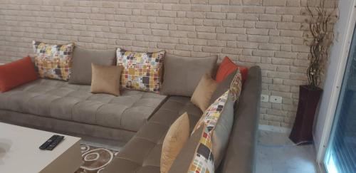 a couch with pillows on it in a living room at Superb & Modern apartment at Berges Lac 2 close to Tunisia Mall in Tunis