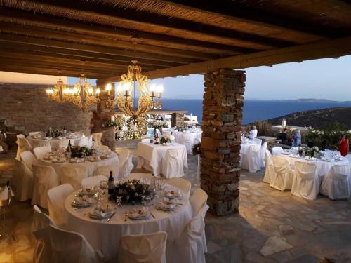 a banquet hall with white tables and chairs at Diles & Rinies in Tinos Town