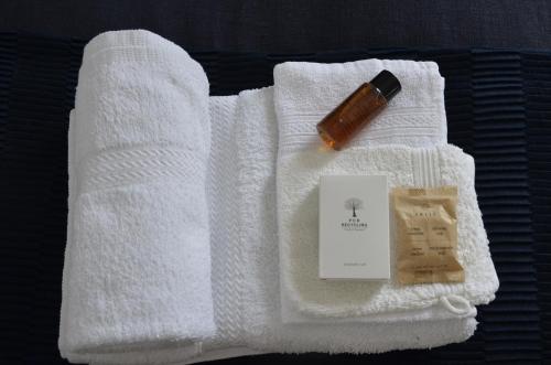 a white towel with a bottle of soap and a cigarette at Castle View Boutique Apartment in Krakow