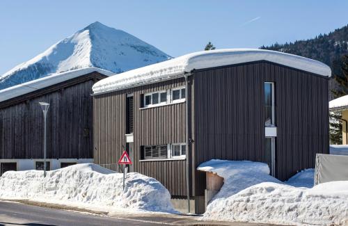 a large black building with snow on the ground at Haus Haag in Achenkirch