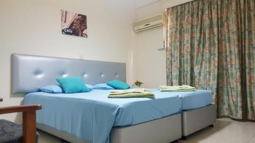 a bedroom with a blue bed with blue pillows at Milounapa in Ayia Napa