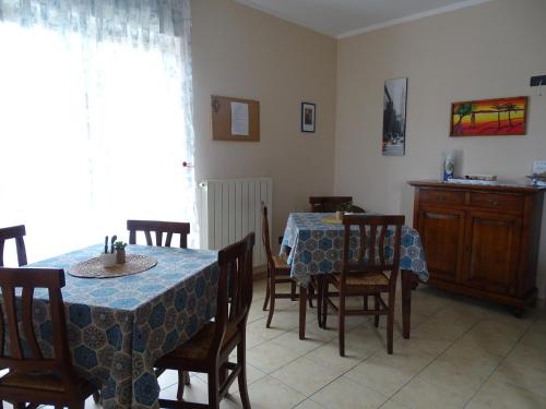 een eetkamer met 2 tafels en stoelen en een tafel en een stoeltje bij Villa Biancofiore in San Giovanni Rotondo