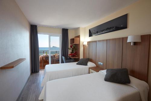 pokój hotelowy z dwoma łóżkami i balkonem w obiekcie Les Dunes Suites w mieście Benidorm