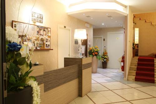 a lobby of a hospital with flowers in the lobby at Hotel Busignani in Rimini