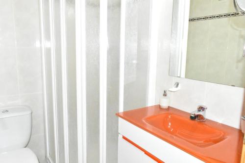 ein Badezimmer mit einem Waschbecken, einem WC und einem Spiegel in der Unterkunft Ventura Park B4 in Salou