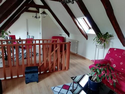 a living room with red chairs and a staircase at La Peupleraie in Bégard