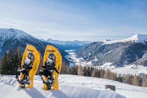 two snowboarders standing on top of a snow covered mountain at Hotel Waldheim in Valle Di Casies