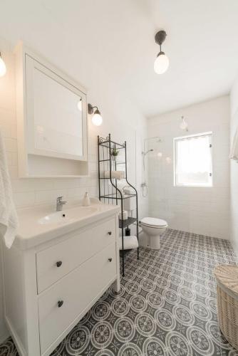 a white bathroom with a sink and a toilet at Beach House Mela in Pag