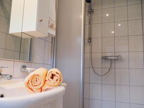 y baño con lavabo y ducha con toallas. en Apartment Silbertal - Ferienwohnung, en Silbertal