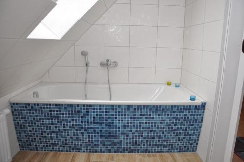 a bathroom with a bath tub with a tile floor at Ferienhaus Müritzzauber / 1 Zimmer Dachgeschoss-Appartement in Röbel