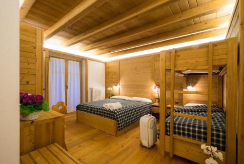 Duas camas num quarto com paredes de madeira em I Riviù em Branzi